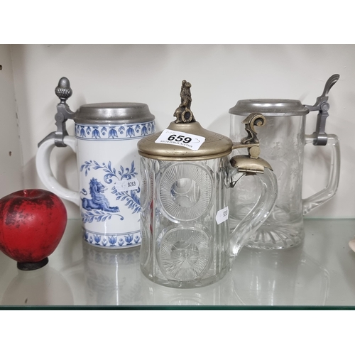 659 - A trio of lidded tankards including two glass examples.