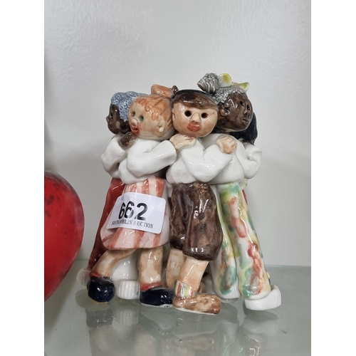 662 - An adorable porcelain figure of a group of young children embracing.