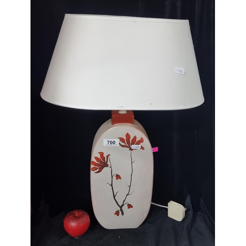 700 - A stylish oval ceramic table lamp with floral design and simple cream shade.