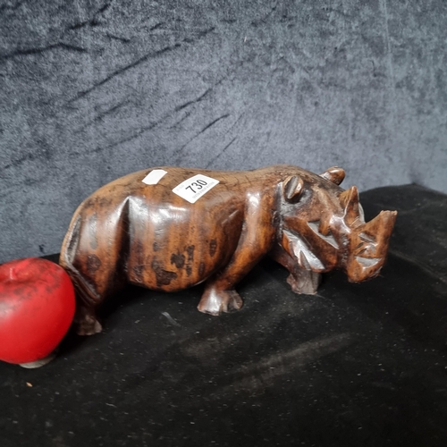 730 - A hand carved solid Mpingo wood sculpture of a rhino. A heavy example. Very small losses.