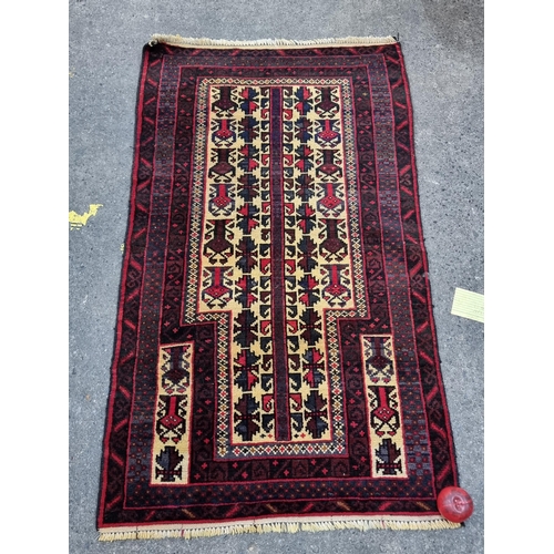 769 - Star Lot : A lovely hand knotted wool rug boasting a geometric design in burgundy, navy and cream. L... 