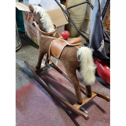 774 - A charming children's rocking horse with reigns and saddle and stirrups. Set on wooden rockers.