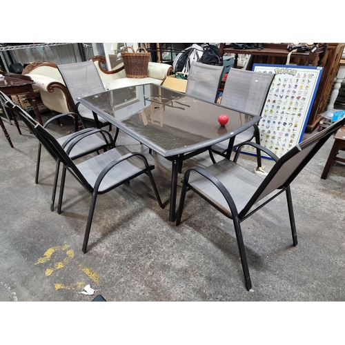 792 - A stylish set of garden table and six chairs. Table features smoked glass top with black metal frame... 