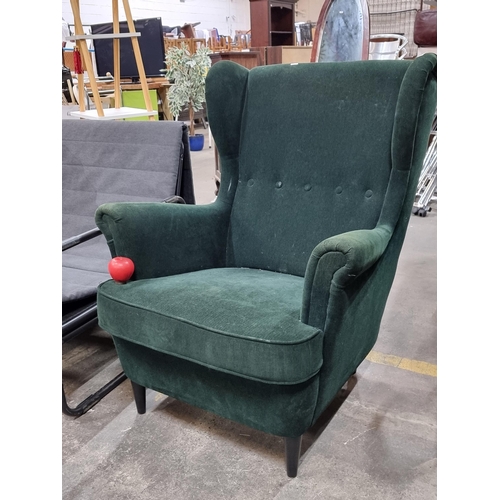 927 - Star Lot : A sophisticated wingback armchair with forest green upholster and elegant buttonback deta... 