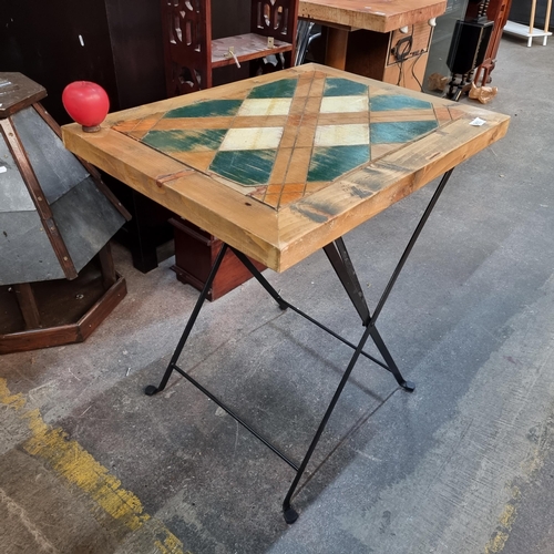 955 - A charming wooden top bistro table featuring a lattice design in green, orange and cream. With metal... 