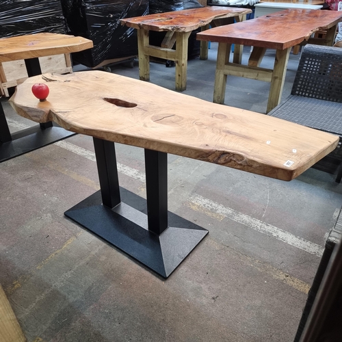 957 - Star Lot : A one of a kind live-edge wood dining table held on contrasting black metal legs, showcas... 