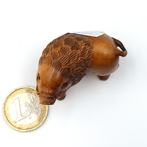 31 - A Japanese Netsuki carved in the form of a wild boar, weight 13.53 grams. With two holes below to ti... 