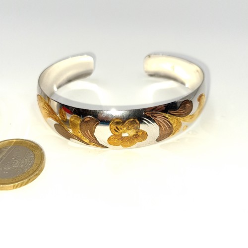 36 - Two sterling silver bangles including a gold leaf design example, weight 12.81 grams together with a... 