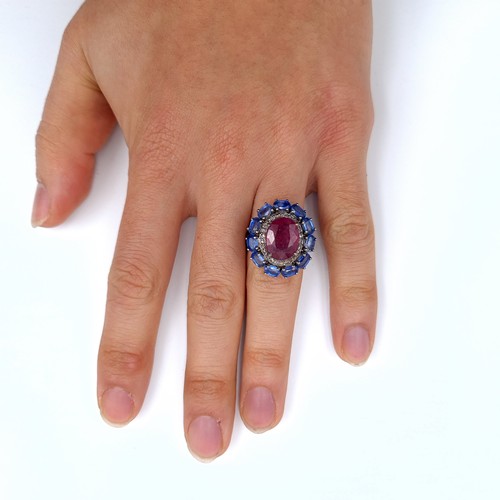 503 - Star Lot : A fabulous huge cabochon ruby  ring mounted  with 11 sapphires and diamond surround, rubi... 