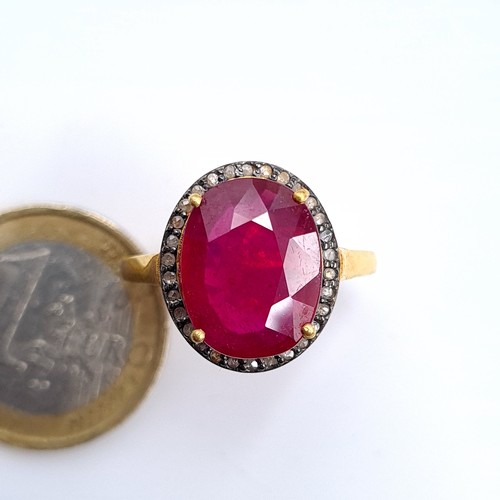 505 - Star Lot : A most attractive gold toned ruby set ring with a diamond surround, ruby is 6.8 cts, ring... 