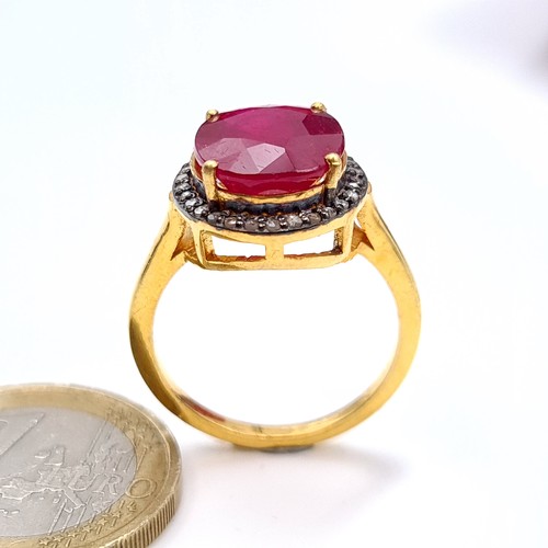 505 - Star Lot : A most attractive gold toned ruby set ring with a diamond surround, ruby is 6.8 cts, ring... 