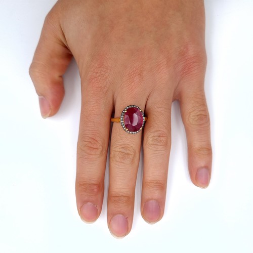 505 - Star Lot : A most attractive gold toned ruby set ring with a diamond surround, ruby is 6.8 cts, ring... 