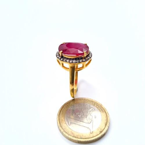 505 - Star Lot : A most attractive gold toned ruby set ring with a diamond surround, ruby is 6.8 cts, ring... 