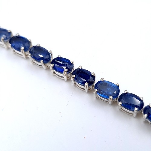 519 - A very nice example of a tennis style bracelet of 28 beautifully matched  sapphires, all set in Ster... 