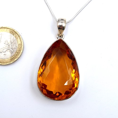 522 - An attractive tear drop facet cut orange topaz pendant and chain, length 44cm, weight 22.6 grams. Br... 