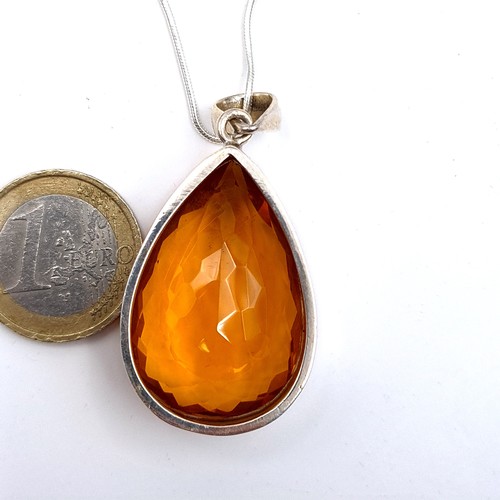 522 - An attractive tear drop facet cut orange topaz pendant and chain, length 44cm, weight 22.6 grams. Br... 