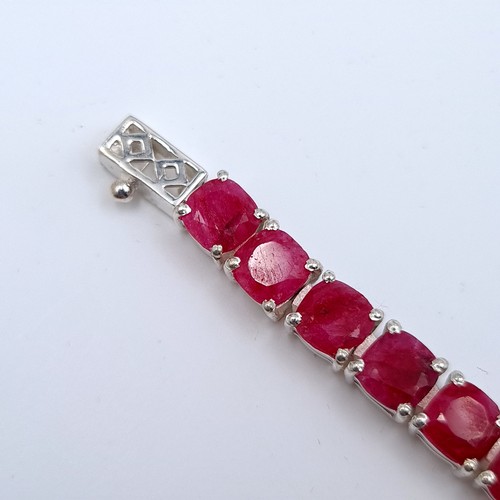 523 - A super example of a 26 gemstone natural ruby line bracelet set in sterling silver, weight 18.54 gra... 