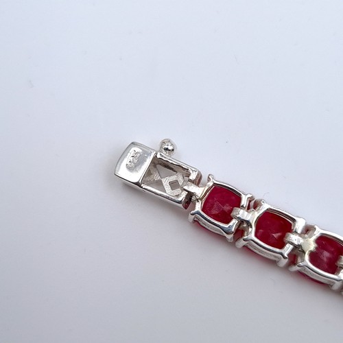 523 - A super example of a 26 gemstone natural ruby line bracelet set in sterling silver, weight 18.54 gra... 