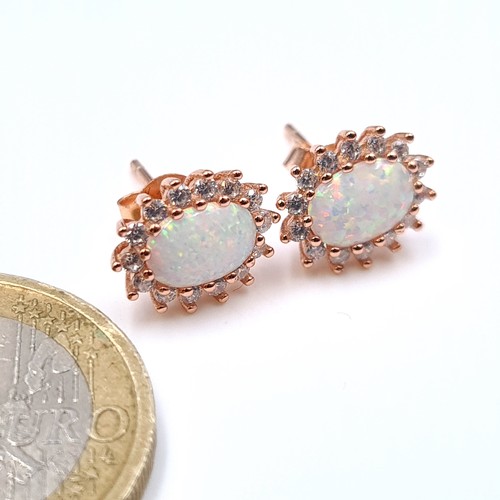 538 - A super pair of opal stone stud earrings set with gem stone surrounds. As new Boxed.