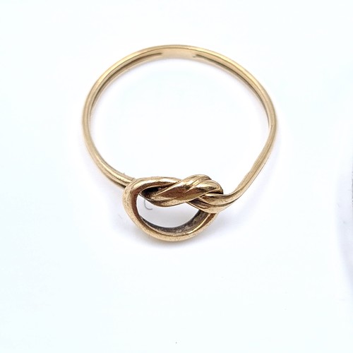 544 - A 9K gold love knot ring, size L, weight 1 gram together with a sterling silver child's bracelet wit... 