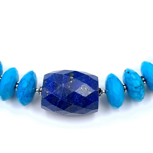 550 - An interesting necklace of graduated disc turquoise stones set with a lapis lazuli accent with black... 