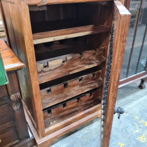 577 - A large handsome solid teak wine rack featuring space for twelve bottles and glasses behind a pierce... 