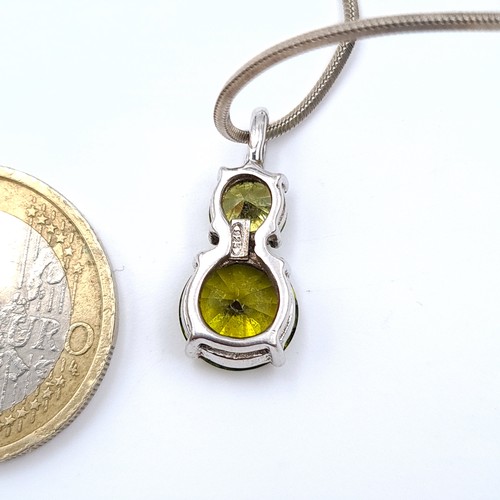 900 - An attractive sterling silver (stamped 925) necklace set with a sparkling green gem-set pendant. Hel... 