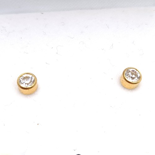 908 - A dazzling pair of gem bezel set stud earrings with 9k gold (stamped 375) butterfly clasps. Held in ... 