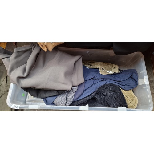 452 - A large crate containing a variety of mens clothing items including a two piece suit, suit trousers,... 