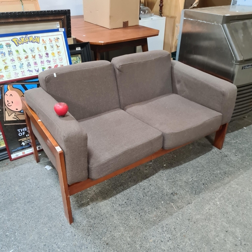 1033 - A stylish two-seater mid century style sofa with a heavy teak frame and comfortable seat cushions in... 