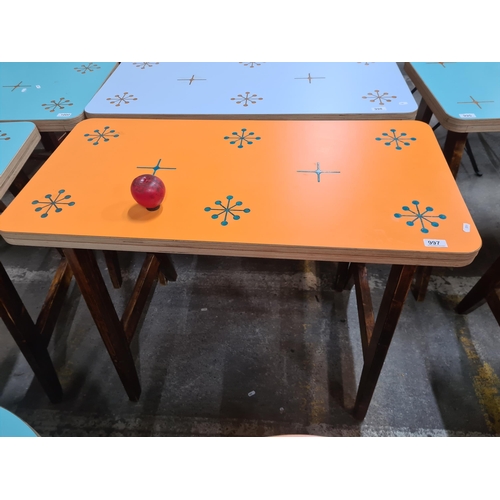 997 - A very stylish dining table with a vibrant orange top featuring a star pattern, held on robust woode... 