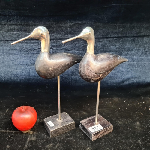 162 - A stylish pair of abstract bird sculptures featuring chrome heads and wooden bodies.