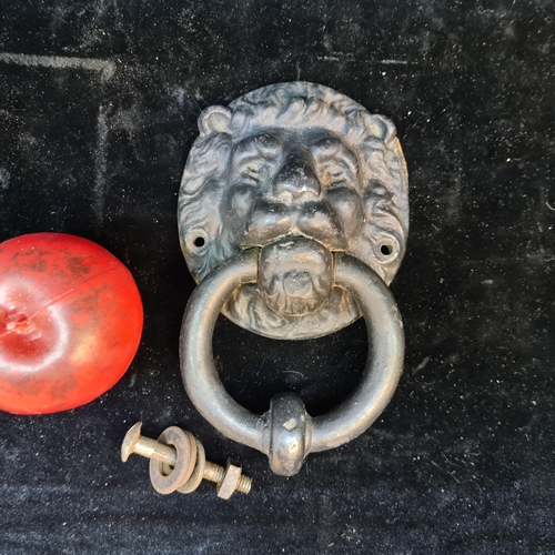 181 - An antique very heavy Irish cast iron door knocker with a lion mask. Accompanied by fittings for mou... 