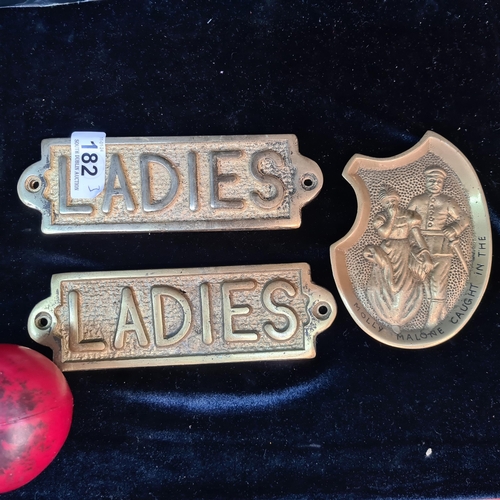 182 - Three brass items including two 'Ladies' plaques and a humorous ashtray featuring Molly Malone.