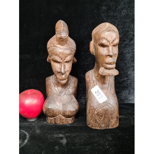 203 - A pair of hand carved solid ironwood African tribal busts depicting a man and woman.