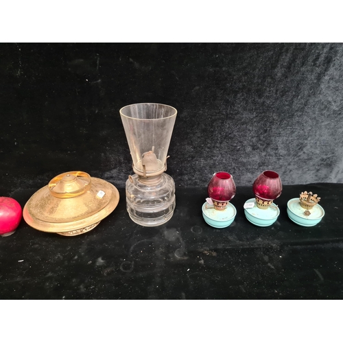 235 - Three dainty matching oil lamps with baby blue bases, two with original ruby glass shades. Along wit... 