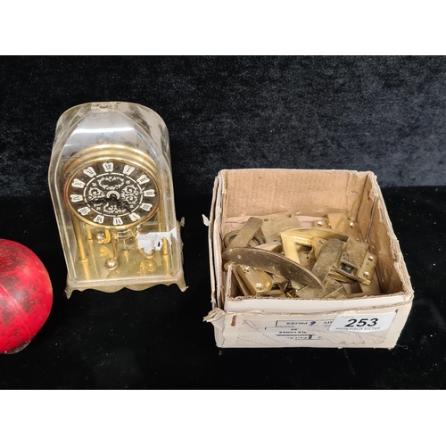 253 - A beautiful miniature dome mantle clock along with a selection of brass table locks for a dining tab... 