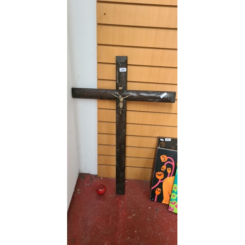 285 - A large antique wooden crucifix with brass detailing.