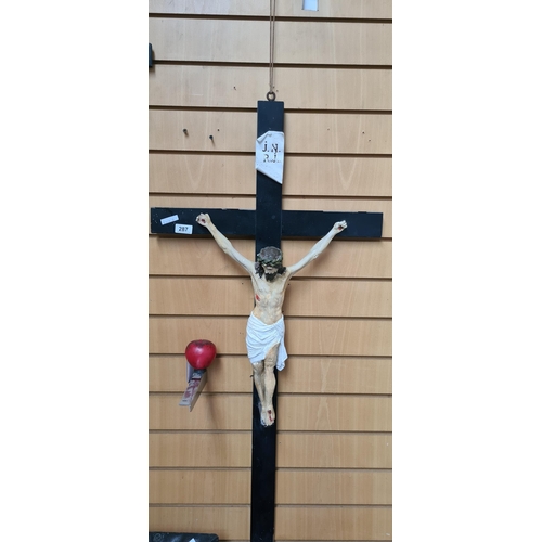 287 - A large antique wooden crucifix with painted cast plaster detailing.