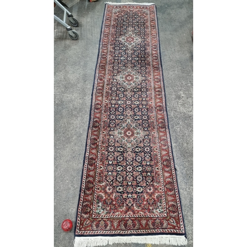 339 - Star Lot : A gorgeous hand knotted woollen hall runner rug with a detailed floral motif in shades of... 