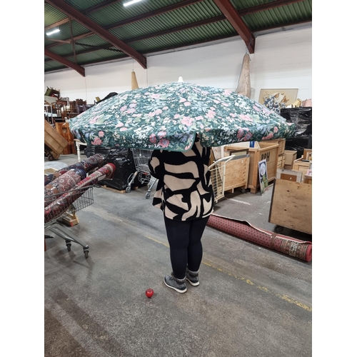 351 - A large outdoor beach umbrella/parasol featuring a colourful floral motif. (person not included )