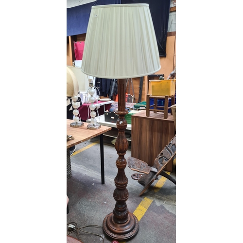 A wonderful large vintage floor standing lamp with turned and carved wood elements and a cream pleated shade.