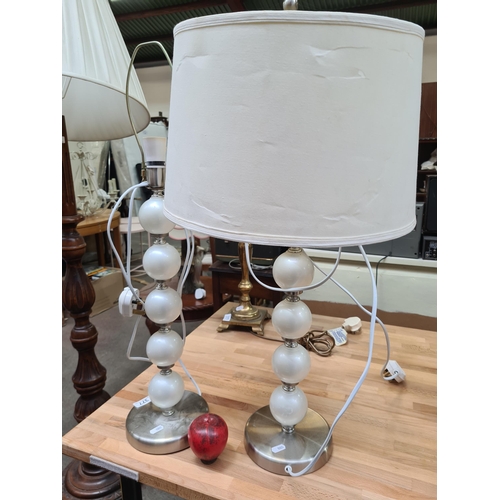 377 - A pair of sleek contemporary cream bubble and chrome table lamps.