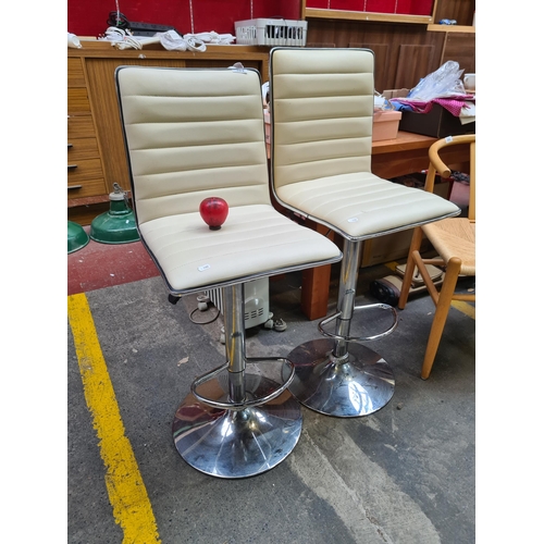 389 - A pair of high quality cream leather and chrome adjustable height bar stools.