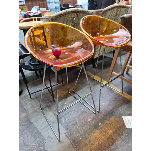 394 - A pair of funky and extremely stylish bar stools boasting an amber seat and chrome base.