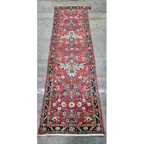 662 - Star Lot : A hand knotted Persian woollen hall runner rug from the Hamadan province. Featuring a flo... 