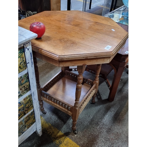 557 - A handsome victorian octagonal occasional table set on enamel castors and featuring a pierced galler... 