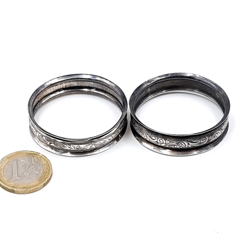 694 - Two sterling silver napkin rings with floral chased design, total weight 6.92 grams.