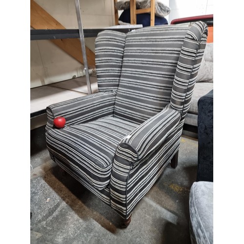 627 - A large comfortable modern wing back armchair upholstered in a smart black and charcoal. In nice con... 