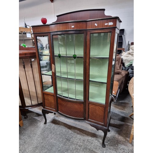 649 - An Edwardian mahogany bow front display cabinet. Astroglazed front with stunning stained glass detai... 